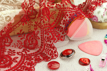Red lace close-up. Lace and sewing accessories. Craft supplies.