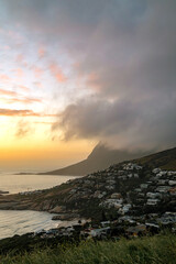 Coastal town at sunset with mountain view. Beautiful landscape, moody sky. Travel destination for tourist. Nature beauty.