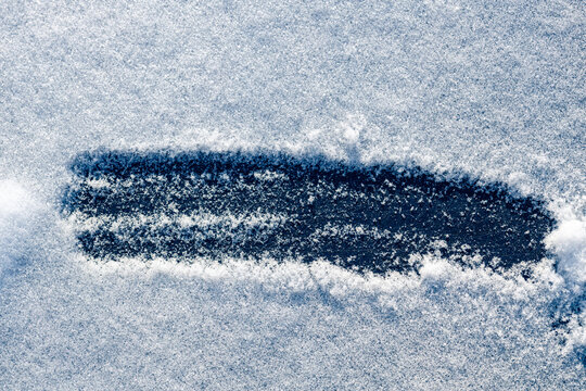 Close-up of snowy background with a hand-drawn stripe on a black background.