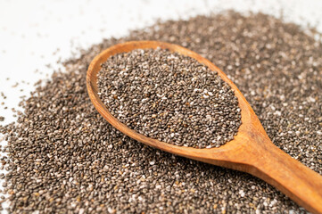 Close-up of chia seeds in wooden spoon. Superfood, organic, healthy dry seeds for meals, breakfast, and desserts. Rich in omega-3, protein and protein. Food background