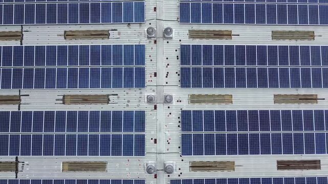 Drone Slowly Ascending Over Solar Panel Rooftop Creating Geometric Pattern of Renewable Energy