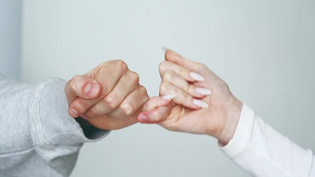 A gesture of reconciliation after a conflict or argument.
A man making peace with a woman, hands on a white background.
Old grudges and friendship
