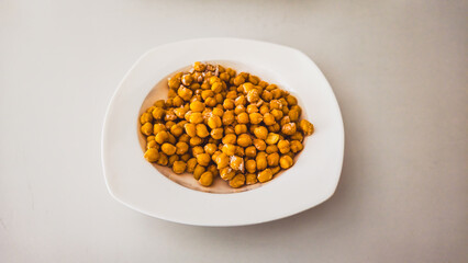 Frozen chickpeas in a white bowl on a white background