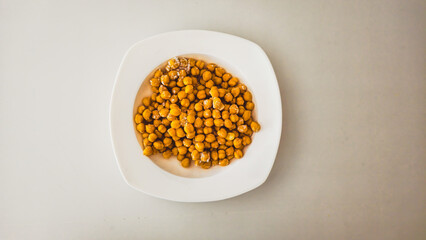 Frozen chickpeas in a white bowl on a white background