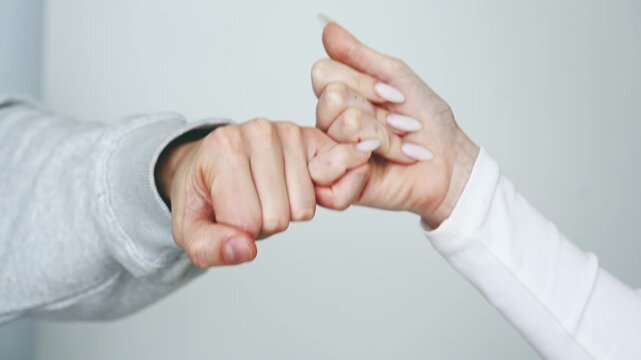 A gesture of reconciliation after a conflict or argument.
A man making peace with a woman, hands on a white background.
Old grudges and friendship