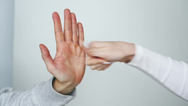 Domestic violence and abusive relationships.
A woman defends herself from a man's attack.
Hands fighting against a white background.
Struggle and conflict