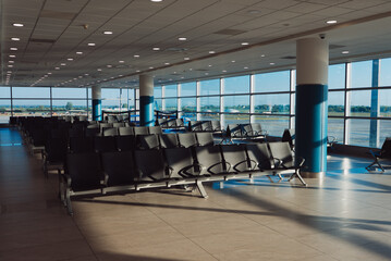 Empty waiting area with seats in a modern international airport terminal.