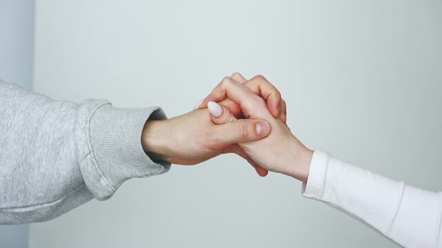 A close-up of two hands touching.
A man's and a woman's hand touching each other against a white background.
A gesture of friendship and support.
Help in a difficult situation.
Friendly hand gestures