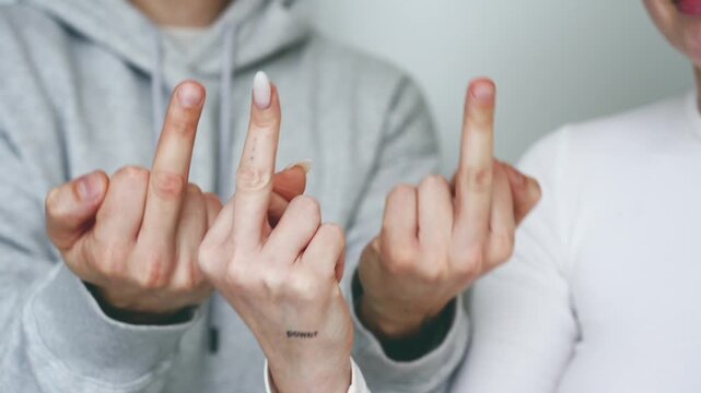 A man and a chewing gum are making a "FUCK YOU" gesture with their fingers.
Obscene hand gestures.
Angry and aggressive gestures.