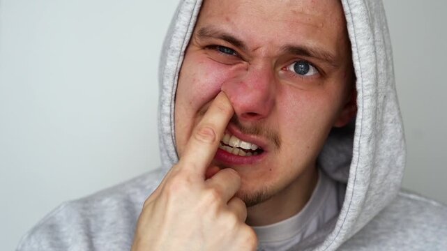 The disgusting and vile habit of picking one's nose.
A man fell asleep with his finger in his nose.
Close-up of a man's finger in his nose.