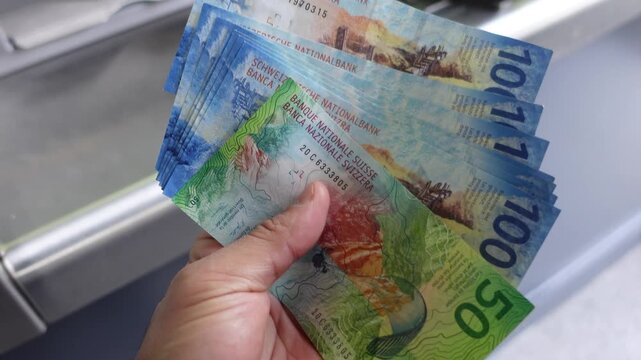 Swiss Franc (CHF) currency withdraw from an ATM in Switzerland showing large denomination banknotes.