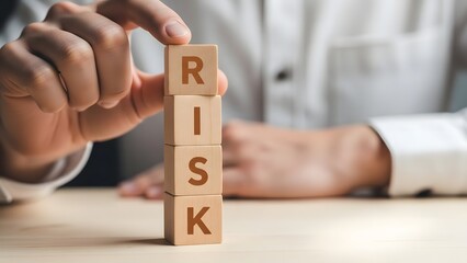 Businessman Touching Stacked Wooden Blocks Spelling Risk to Represent Strategy and Financial Safety