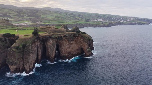 Aerial view over volcanic coast, Atlantic ocean waves, Azores, Sao Miguel island, travel destination.