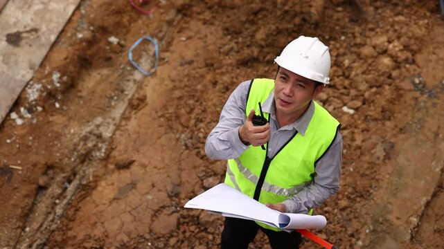 top view. communicate by walkie talkie transmitter, radio. Professional Architects Engineer working at construction site. Architect or contractor working on house building under construction site