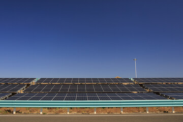 Solar panels under clear blue sky capture sunlight for renewable energy production, showcasing sustainable technology in rural setting