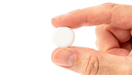 Individual nitroglycerin tablet held between fingers on white backdrop emphasizing dosage form for quick absorption in angina treatment.
