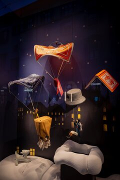 Milan, Italy - 2026, 13 Jan: Striking Hermes FW25 window display features floating scarves and chic accessories in a whimsical, imaginative nighttime cityscape