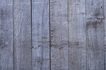 Vertical weathered wood planks with grain and knots showing natural aging and texture