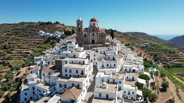 Aerial view of whitewashed village on hillside landscape under clear blue sky