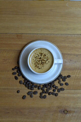 Top view of cappuccino and coffee beans on a wooden table