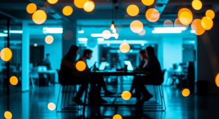 Modern office workers collaborating in trendy blue lit workspace with yellow bokeh lights