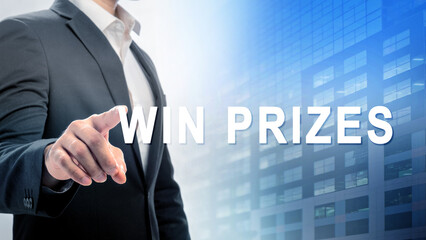 Businessman in a suit touches a digital screen with the text "Win Prizes" displayed. The background feature of a modern glass building. Concept of online contest, giveaway, raffle, or lottery