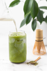 Matcha tea. Iced green tea matcha latte in glass. Green tea dalgona, whipped green tea with milk. Healthy vegan drink, close up.