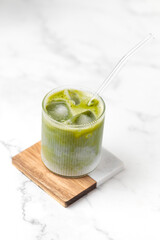 Matcha tea. Iced green tea matcha latte in glass. Green tea dalgona, whipped green tea with milk. Healthy vegan drink, close up.