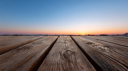 Naklejka premium Wooden planks extend towards a clear horizon under a vibrant dawn or dusk sky