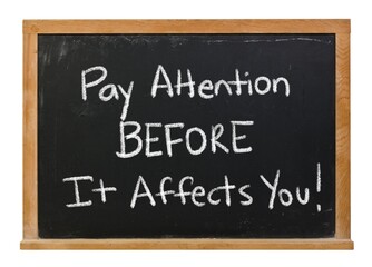 Obraz premium Pay attention BEFORE it affects you written in white chalk on a black chalkboard in a wooden frame isolated on white