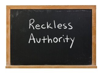 Obraz premium Reckless Authority written in white chalk on a black chalkboard in a wooden frame isolated on white