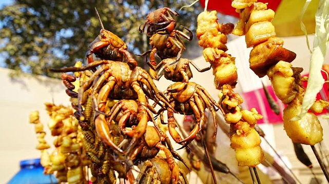 River crabs and pieces of meat are skewered and grilled at a roadside food stall during Magh Bihu celebrations, highlighting traditional Assamese street food prepared for the harvest festival