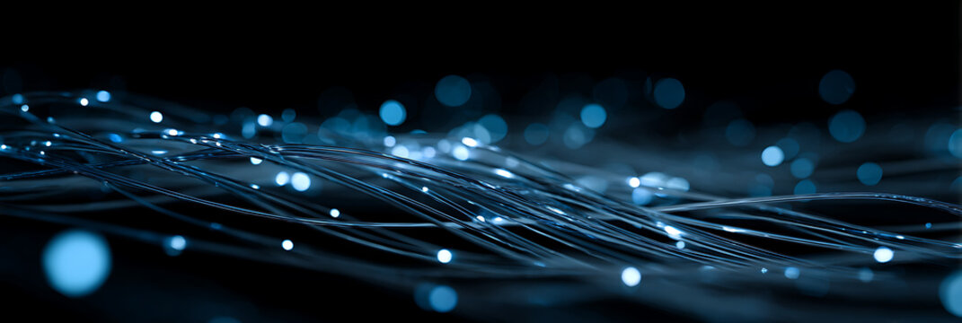 High speed fiber optic cable network for fast internet data transfer and digital communication technology background with glowing blue light particles and bokeh effects on black.