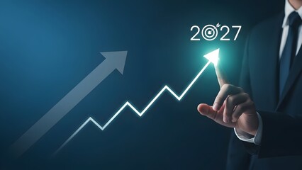 Obraz premium Businessman Pointing to Rising Growth Graph with 2027 Target Goal for Business Success and Financial Strategy Concept