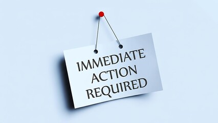 White paper sign with bold black text 'IMMEDIATE ACTION REQUIRED' pinned to a light blue wall with a red thumbtack