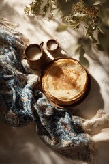 Freshly made flatbreads on a wooden plate beside a cup of milk and a small dish of sugar