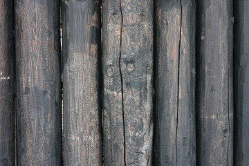 Fototapeta premium vertical logs are dark in color with cracks and signs of wear