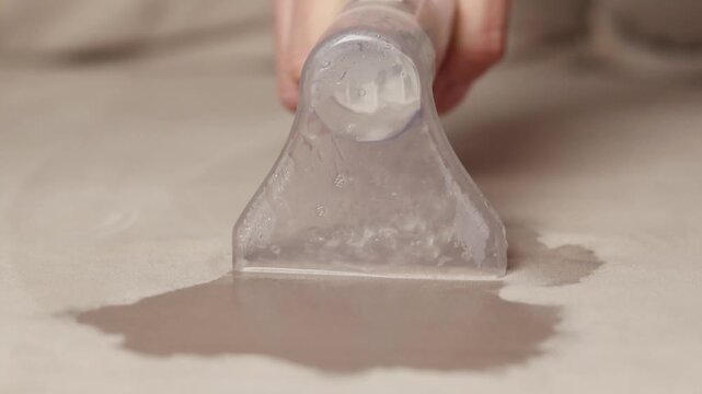 Close up footage, Washing vacuum cleaner. Wet cleaning of the gray sofa, furniture. 4k