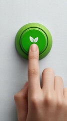 Finger presses a green eco button with leaf symbol representing sustainability and growth
