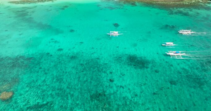 Tour boats running over clear turquoise sea water. Boracay, Philippines.