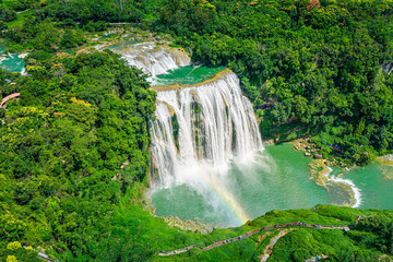 Fototapeta premium Majestic Huangguoshu Waterfall with a rainbow in Guizhou, China during a sunny day.