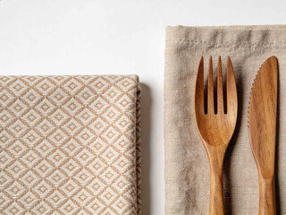 Natural wooden fork and knife set on a textured napkin with a patterned cloth