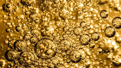 Golden bubbles floating in liquid, abstract background with macro photography.