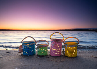 playful maritime lanterns with candle at the beach in sunset	