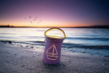 unique self crafted lantern with candle inside near the sea	