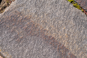 斜めの模様と緑の苔が特徴的な平らな石のテクスチャ