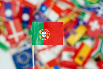 Small flag of Portugal in front of a collection of various flags from different countries