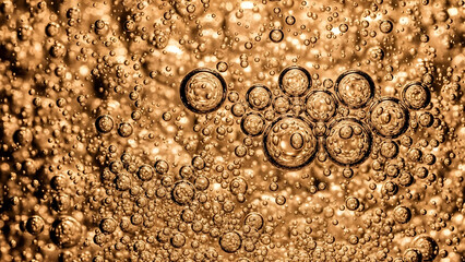 Golden liquid with many bubbles, abstract background for design.
