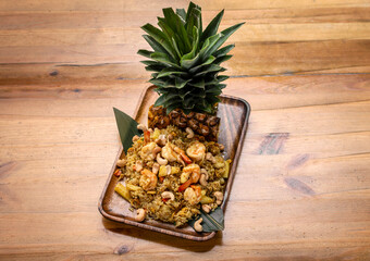 Thai chicken fried rice with pineapple and cashew on modrn bangkok restaurant table in thailand