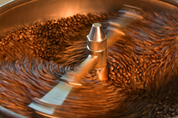 close up view of coffee beans roasting in machine